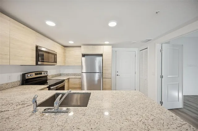 a kitchen with a refrigerator a stove and a sink with wooden floor