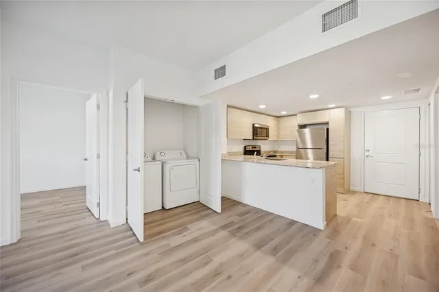 a view of a kitchen with wooden floor and window