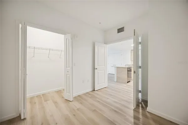 a view of a hallway with wooden floor and closet area