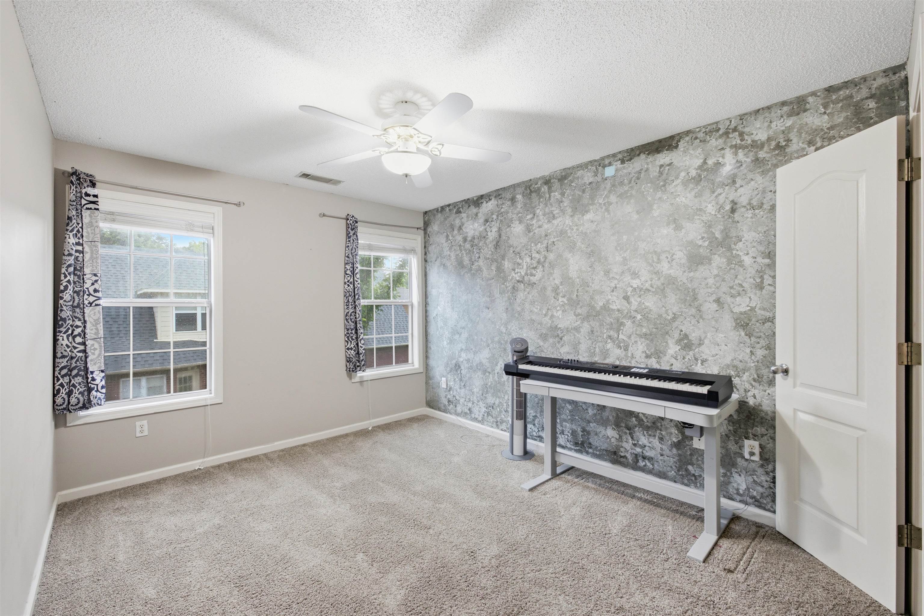 96 Berryfield Cove Collierville, TN 38017 - Photo 25 of 39 Bedroom featuring a textured accent wall, two large windows, and neutral carpeting