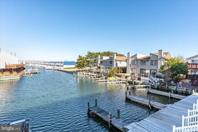 a view of an ocean with boats and trees in the background
