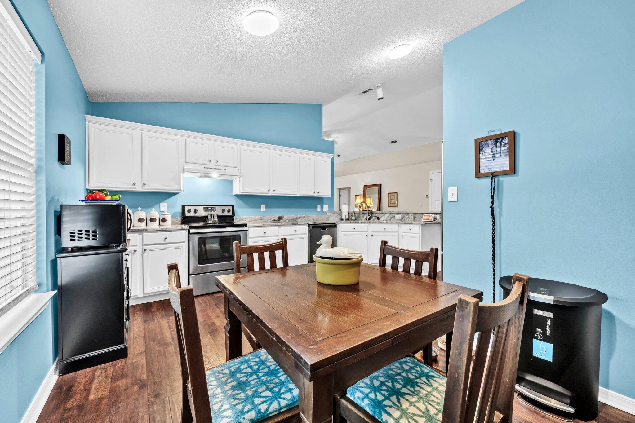 174 Bayou Landing Road Miramar Beach, FL 32550 - Photo 15 of 42 a kitchen with stainless steel appliances granite countertop a refrigerator a stove a sink a dining table and chairs
