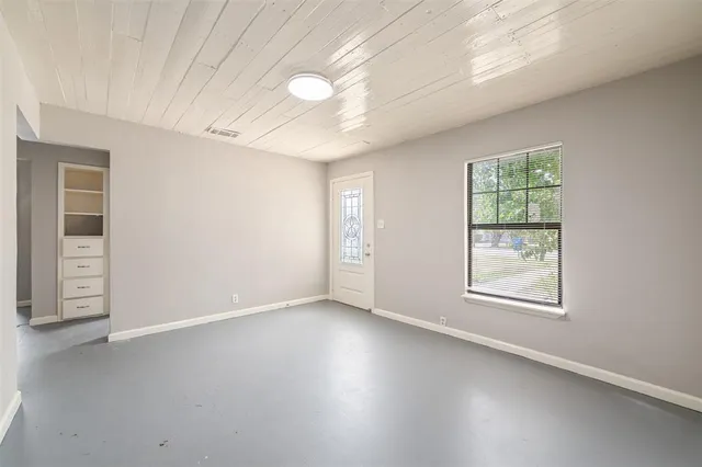an empty room with windows and closet