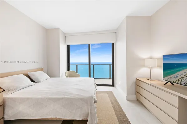 a bedroom with a bed and large window