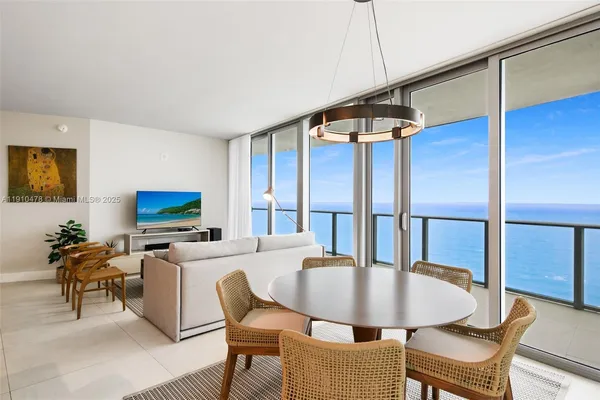 a kitchen with stainless steel appliances kitchen island granite countertop a table chairs microwave and sink