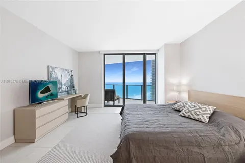 a bedroom with a bed and a mirror on the dresser