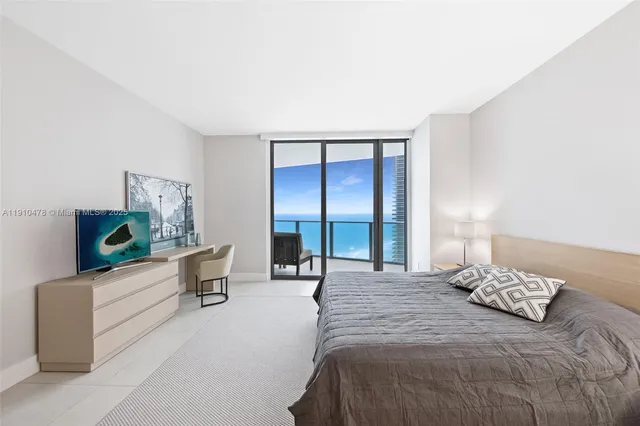 a bedroom with a bed and a mirror on the dresser