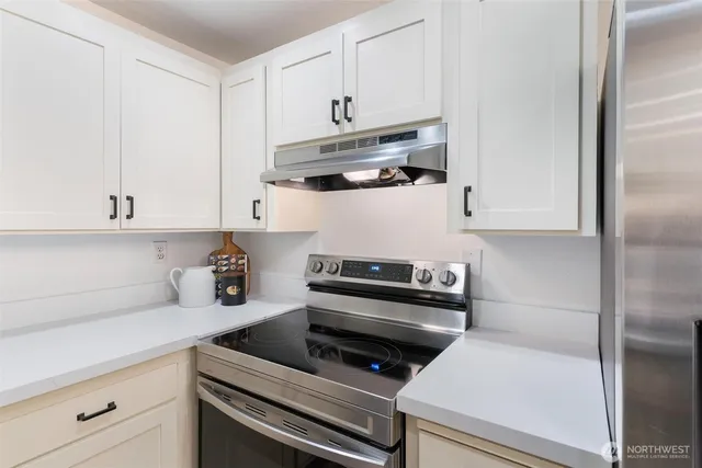 a kitchen with white cabinets and appliances