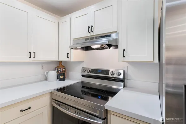 a kitchen with white cabinets and appliances