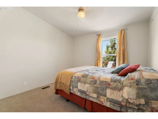 a bed sitting in a bedroom next to a window