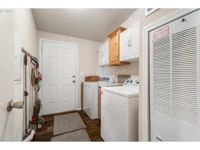 a kitchen with a refrigerator a stove and white cabinets