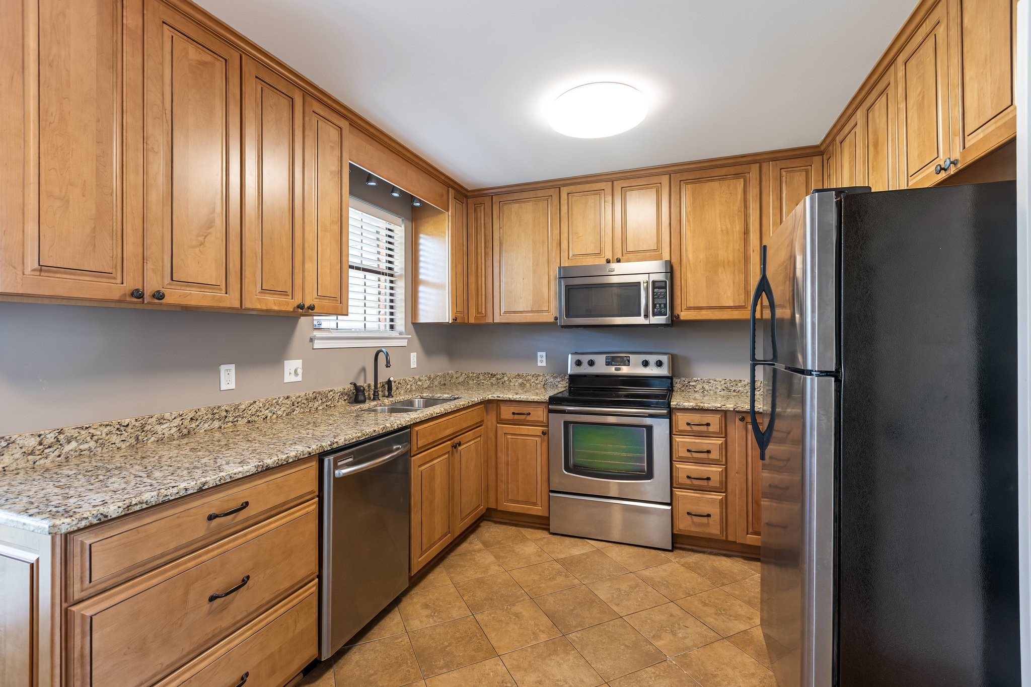 1216 General George Patton Road Nashville, TN 37221 - Photo 13 of 32 a kitchen with stainless steel appliances granite countertop a refrigerator stove a sink and dishwasher