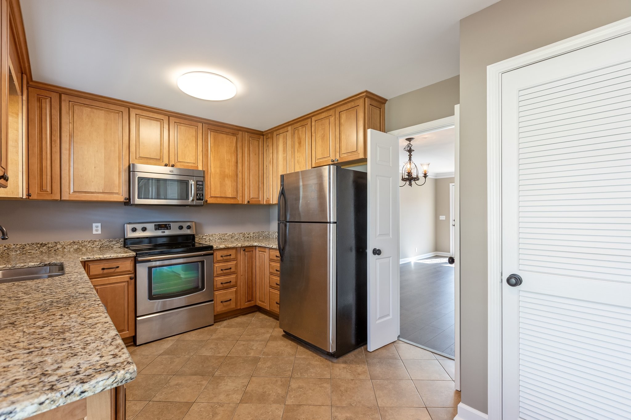 1216 General George Patton Road Nashville, TN 37221 - Photo 15 of 32 a kitchen with stainless steel appliances granite countertop a refrigerator and a stove top oven