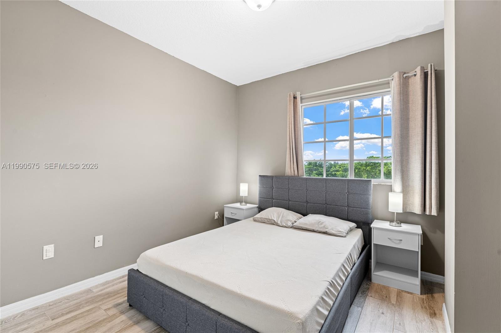 5271 Southwest 8th Street, Unit 315 Miami, FL 33134 - Photo 8 of 25 a bed sitting in a bedroom next to a window