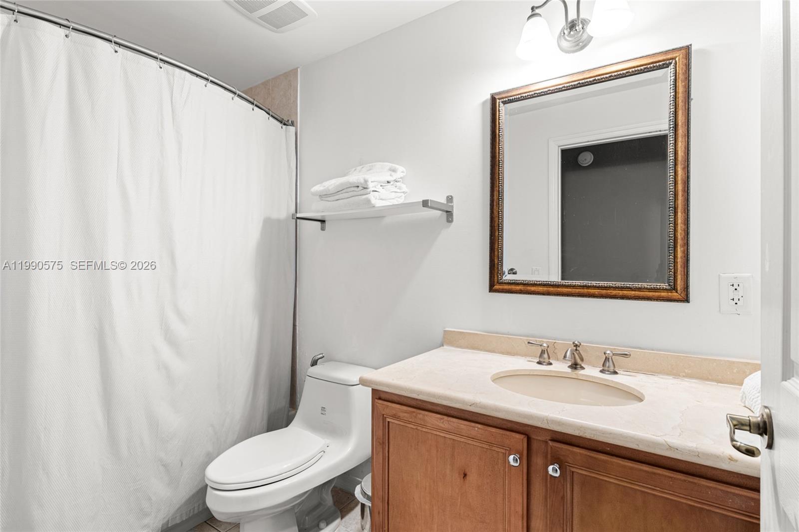 5271 Southwest 8th Street, Unit 315 Miami, FL 33134 - Photo 9 of 25 a bathroom with a sink vanity mirror and toilet