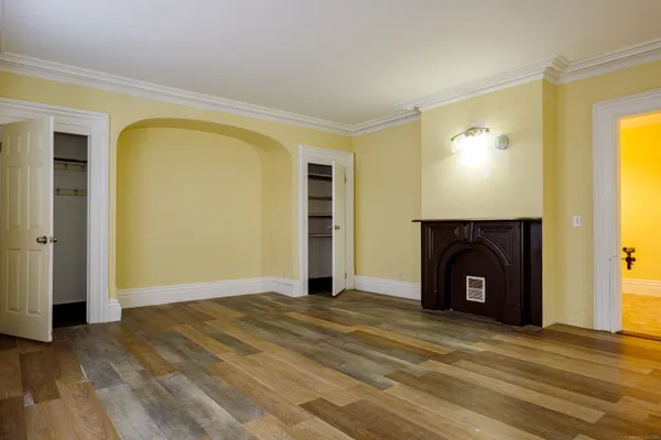 a view of empty room with a fireplace and wooden floor
