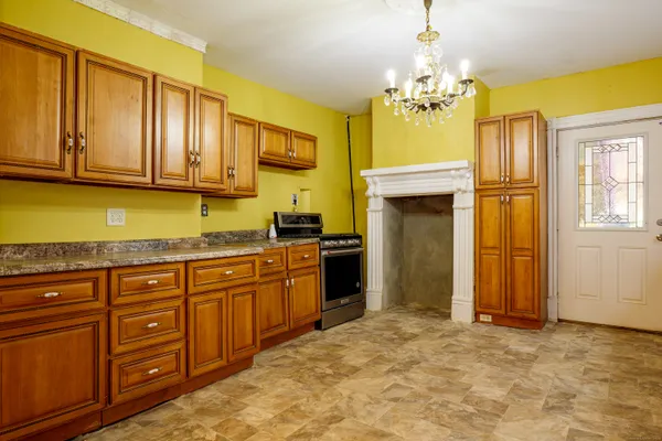 a kitchen with a granite countertop stove top oven a sink dishwasher and a refrigerator with wooden floor