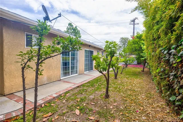 a porch with a table and chairs and potted plants