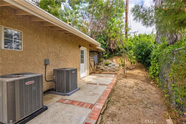 a view of a pathway of a house with wooden fence