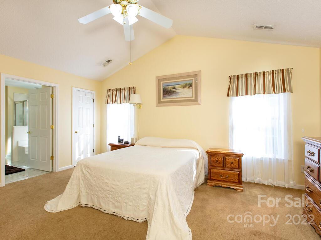 294 Farm Valley Road Fletcher, NC 28732 - Photo 16 of 36 a spacious bedroom with a bed and a chandelier