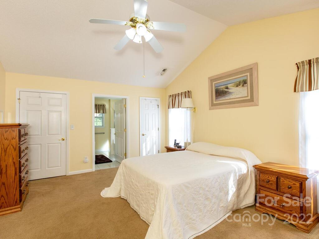 294 Farm Valley Road Fletcher, NC 28732 - Photo 17 of 36 a spacious bedroom with a bed and a chandelier