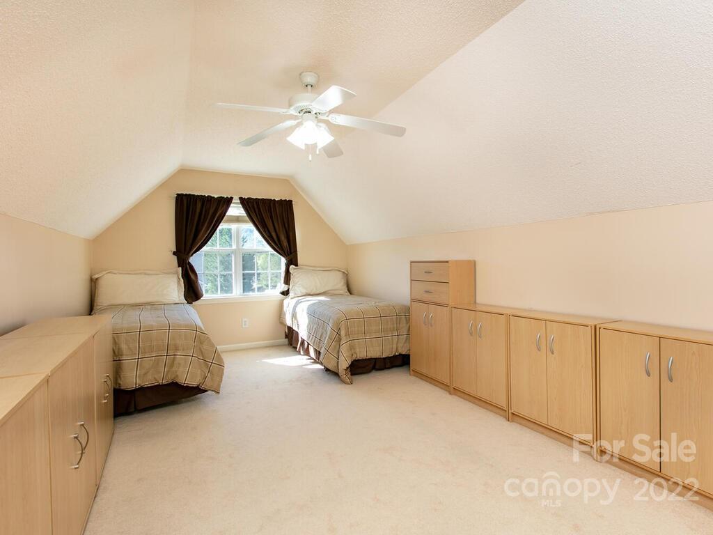 294 Farm Valley Road Fletcher, NC 28732 - Photo 27 of 36 a bedroom with a white bed and a chandelier