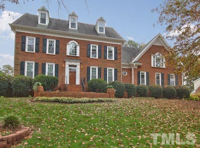 8917 Wildwood Links Raleigh, NC 27613 - Photo 1 of 25 a front view of a house with a yard