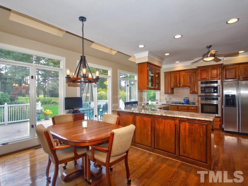8917 Wildwood Links Raleigh, NC 27613 - Photo 2 of 25 a dining room with furniture a chandelier and wooden floor