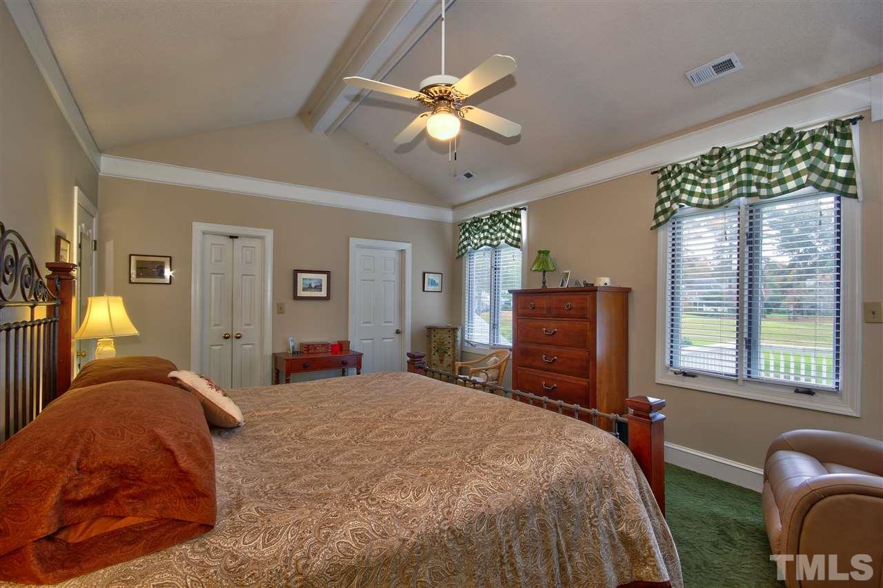 8917 Wildwood Links Raleigh, NC 27613 - Photo 12 of 25 a bedroom with a bed and dresser with mirror