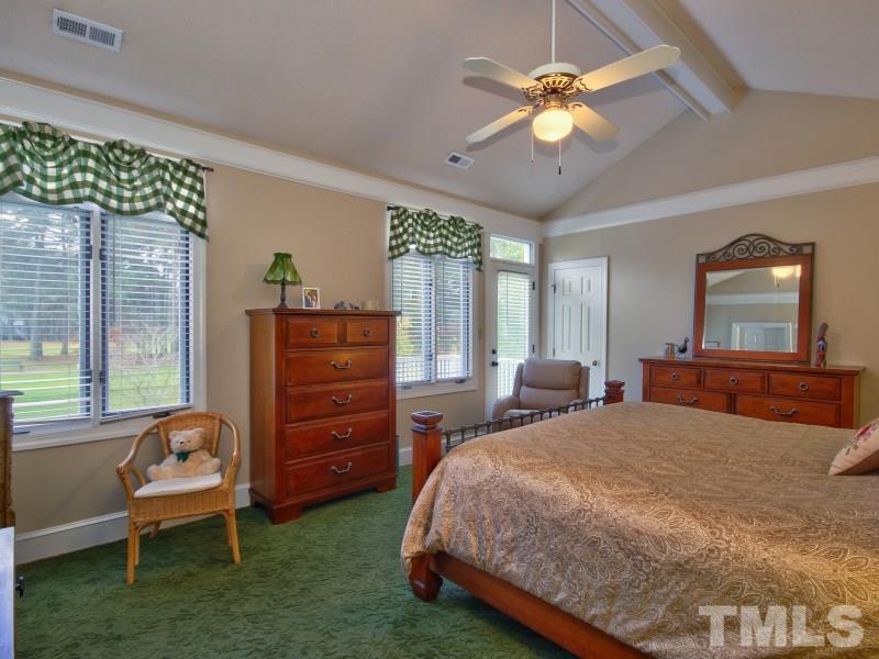 8917 Wildwood Links Raleigh, NC 27613 - Photo 13 of 25 a bedroom with a bed dresser and a window