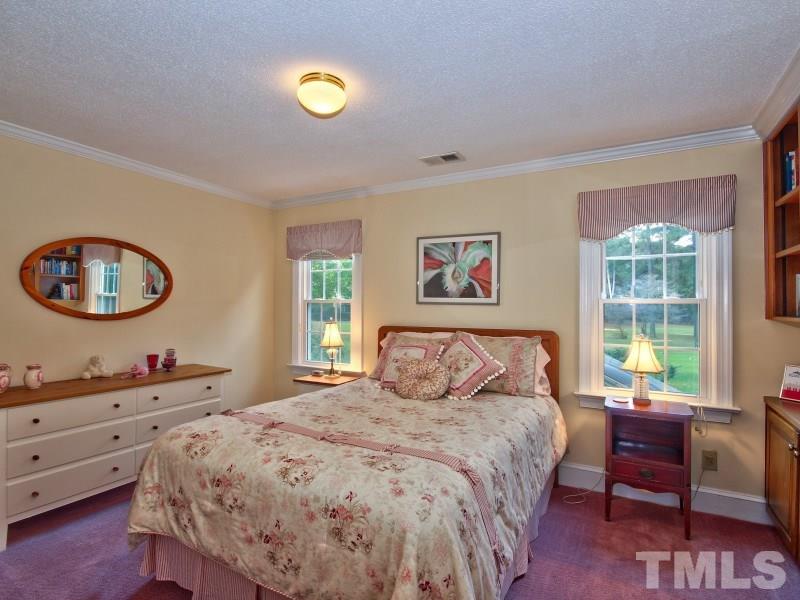 8917 Wildwood Links Raleigh, NC 27613 - Photo 17 of 25 a bedroom with a bed and a window