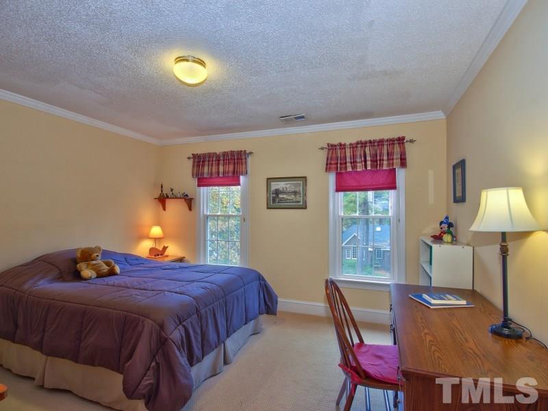 8917 Wildwood Links Raleigh, NC 27613 - Photo 19 of 25 a bed room with a bed and a lamp