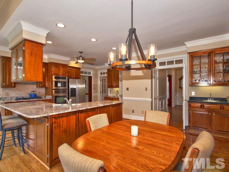 8917 Wildwood Links Raleigh, NC 27613 - Photo 4 of 25 a kitchen with stainless steel appliances granite countertop a sink and refrigerator