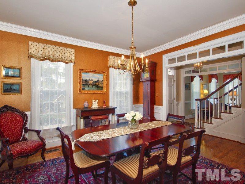 8917 Wildwood Links Raleigh, NC 27613 - Photo 8 of 25 a dining room with furniture a chandelier and wooden floor