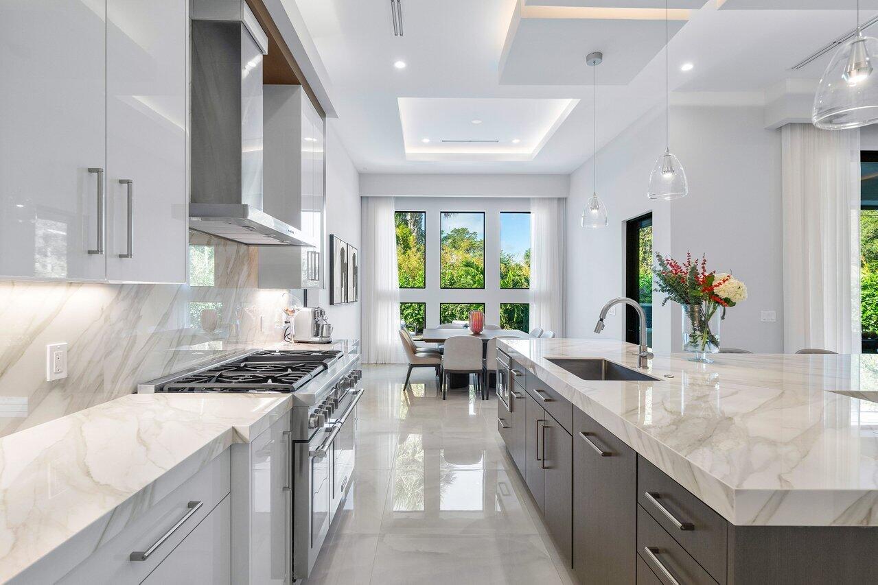 1099 Northeast 2nd Terrace Boca Raton, FL 33432 - Photo 12 of 43 a kitchen with stainless steel appliances a sink stove and cabinets