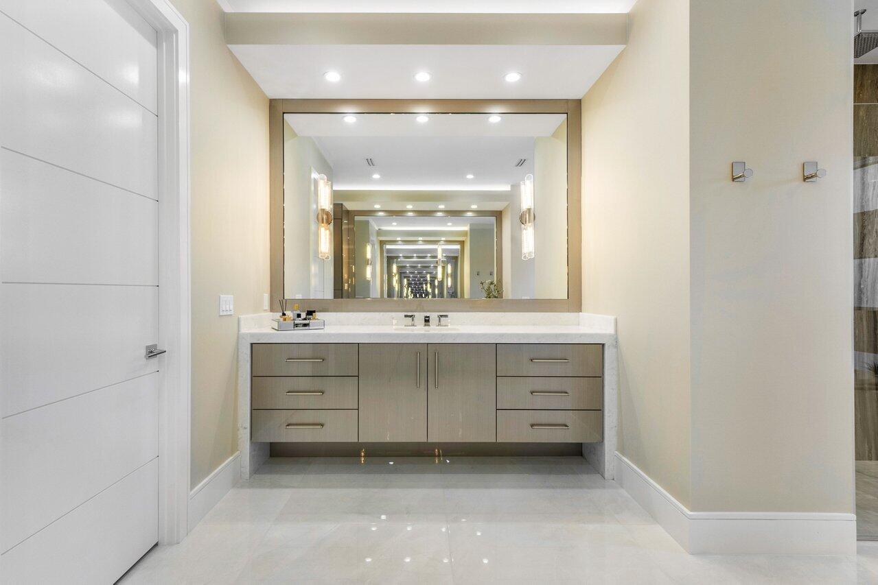 1099 Northeast 2nd Terrace Boca Raton, FL 33432 - Photo 20 of 43 a bathroom with a vanity a sink a mirror a window and a bathtub