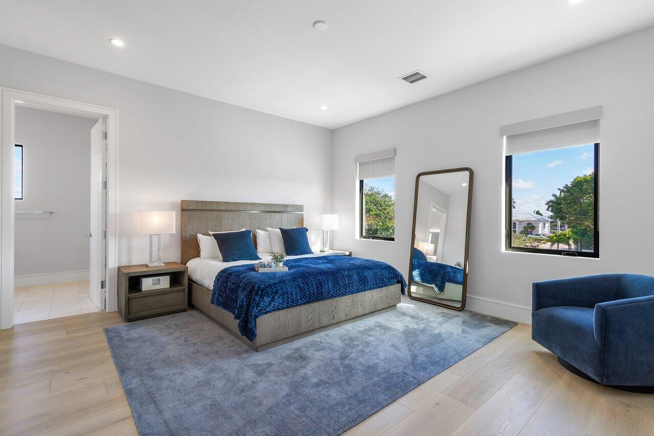 1099 Northeast 2nd Terrace Boca Raton, FL 33432 - Photo 25 of 43 a spacious bedroom with a large bed and a couch