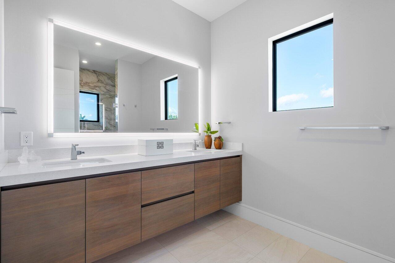 1099 Northeast 2nd Terrace Boca Raton, FL 33432 - Photo 26 of 43 a bathroom with a double vanity sink and a mirror