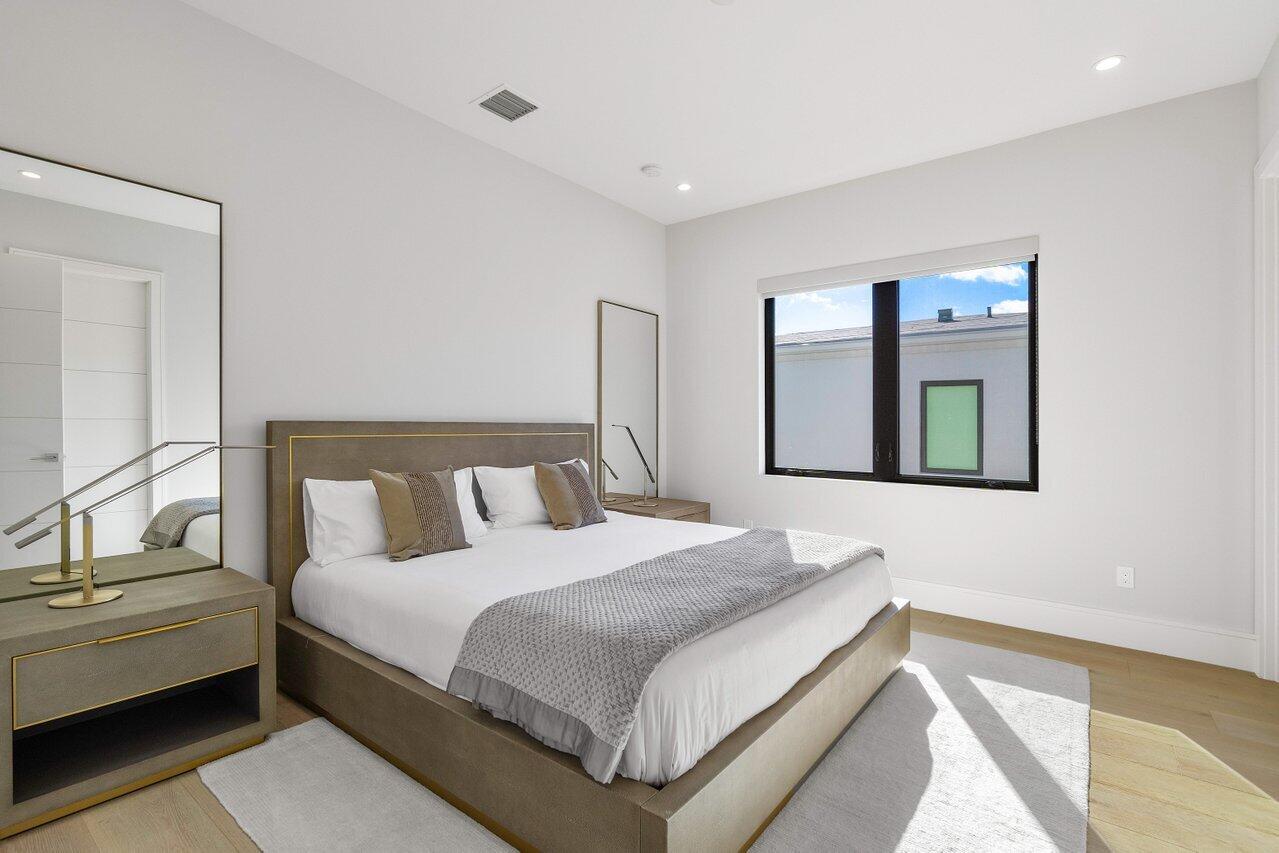 1099 Northeast 2nd Terrace Boca Raton, FL 33432 - Photo 27 of 43 a bedroom with a bed lamps and window