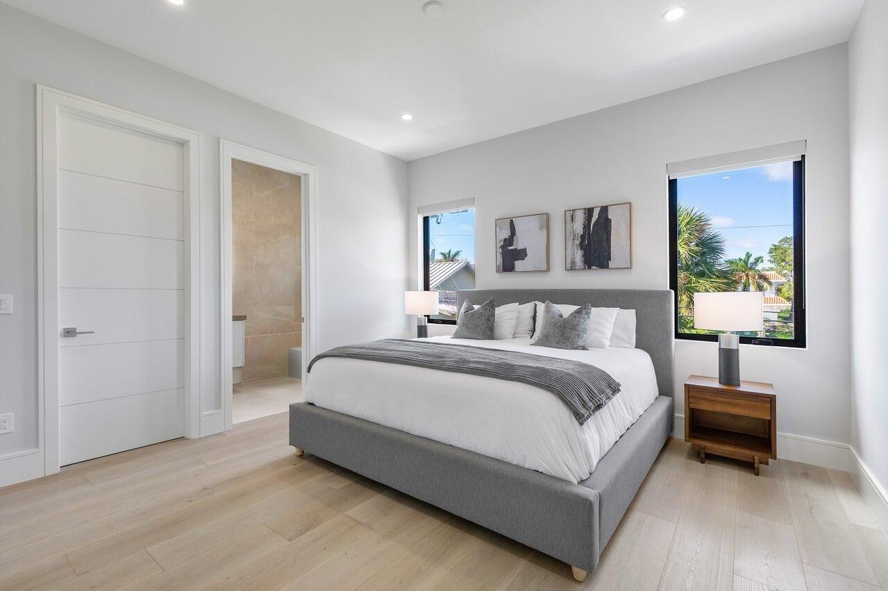 1099 Northeast 2nd Terrace Boca Raton, FL 33432 - Photo 29 of 43 a spacious bedroom with a bed and a couch