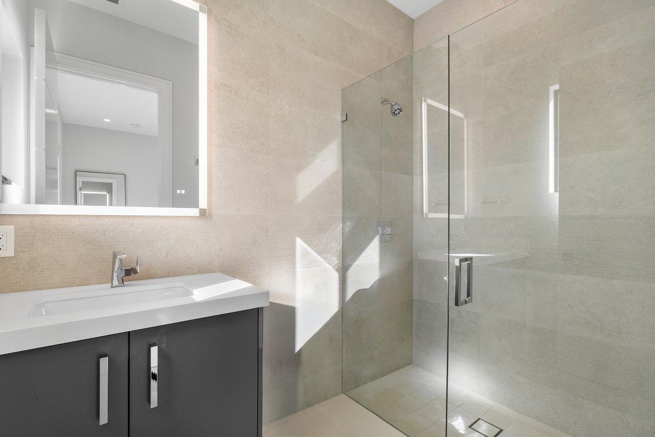 1099 Northeast 2nd Terrace Boca Raton, FL 33432 - Photo 30 of 43 a bathroom with a double vanity sink mirror and shower