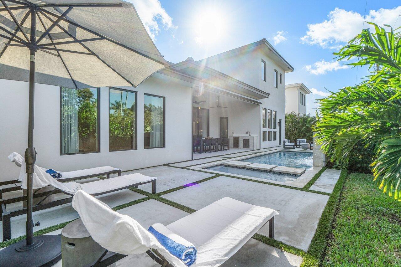 1099 Northeast 2nd Terrace Boca Raton, FL 33432 - Photo 34 of 43 a view of a patio with table and chairs potted plants and floor to ceiling window