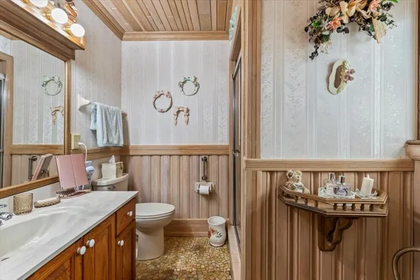 a bathroom with a granite countertop sink a toilet and a shower curtain