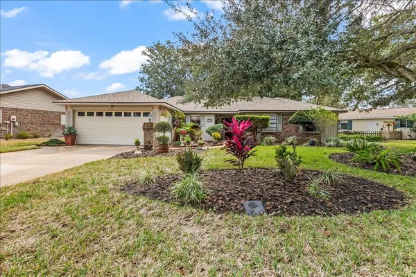 a view of a house with a yard and large trees