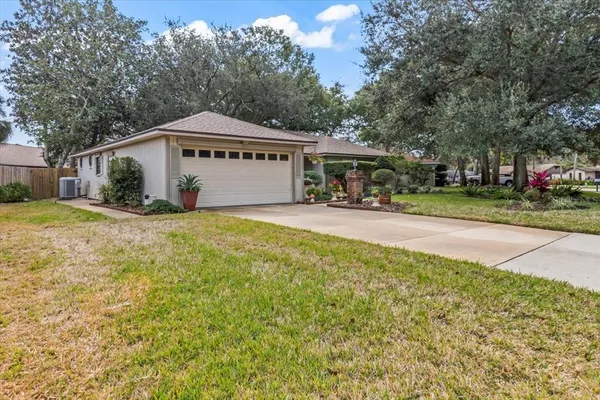 a view of house with yard and trees in the background