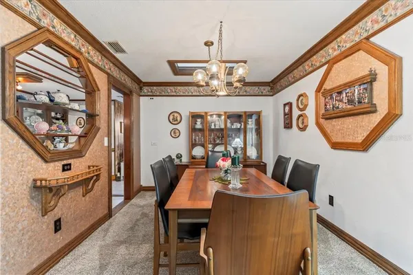 a view of a dining room with furniture and a chandelier