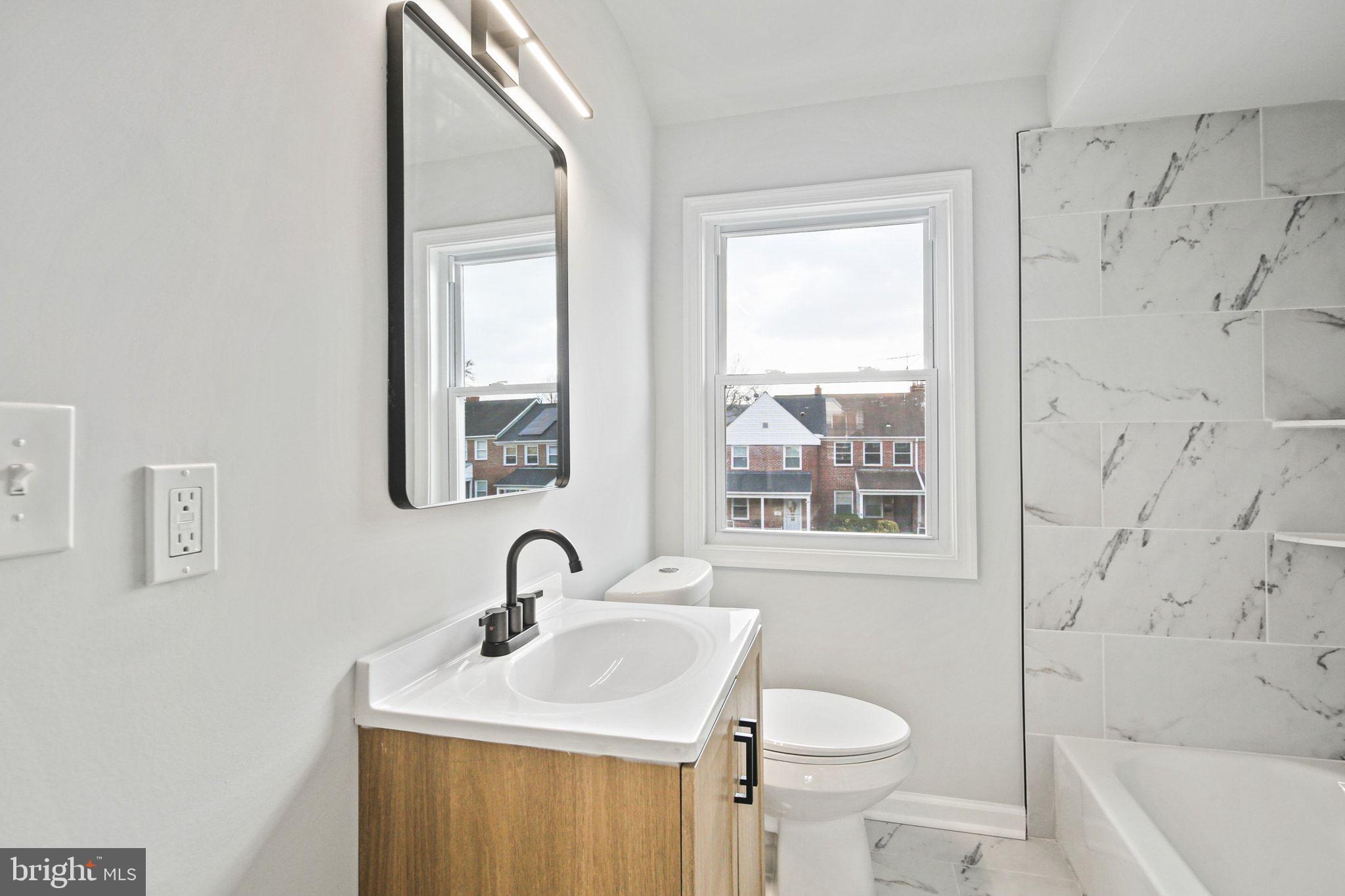 1322 Kitmore Road Baltimore, MD 21239 - Photo 14 of 34 a bathroom with a sink a toilet and a window