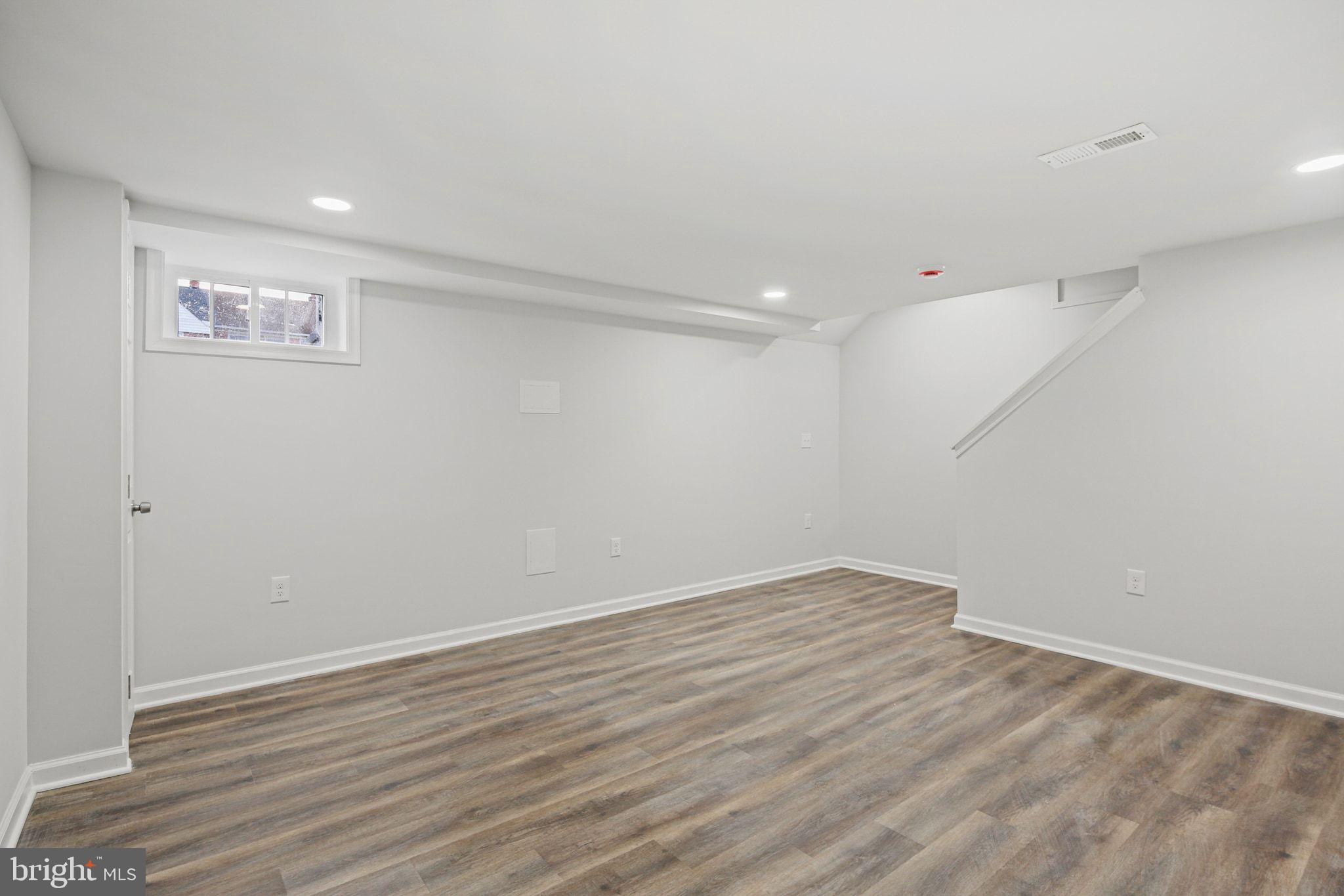 1322 Kitmore Road Baltimore, MD 21239 - Photo 24 of 34 an empty room with wooden floor and windows