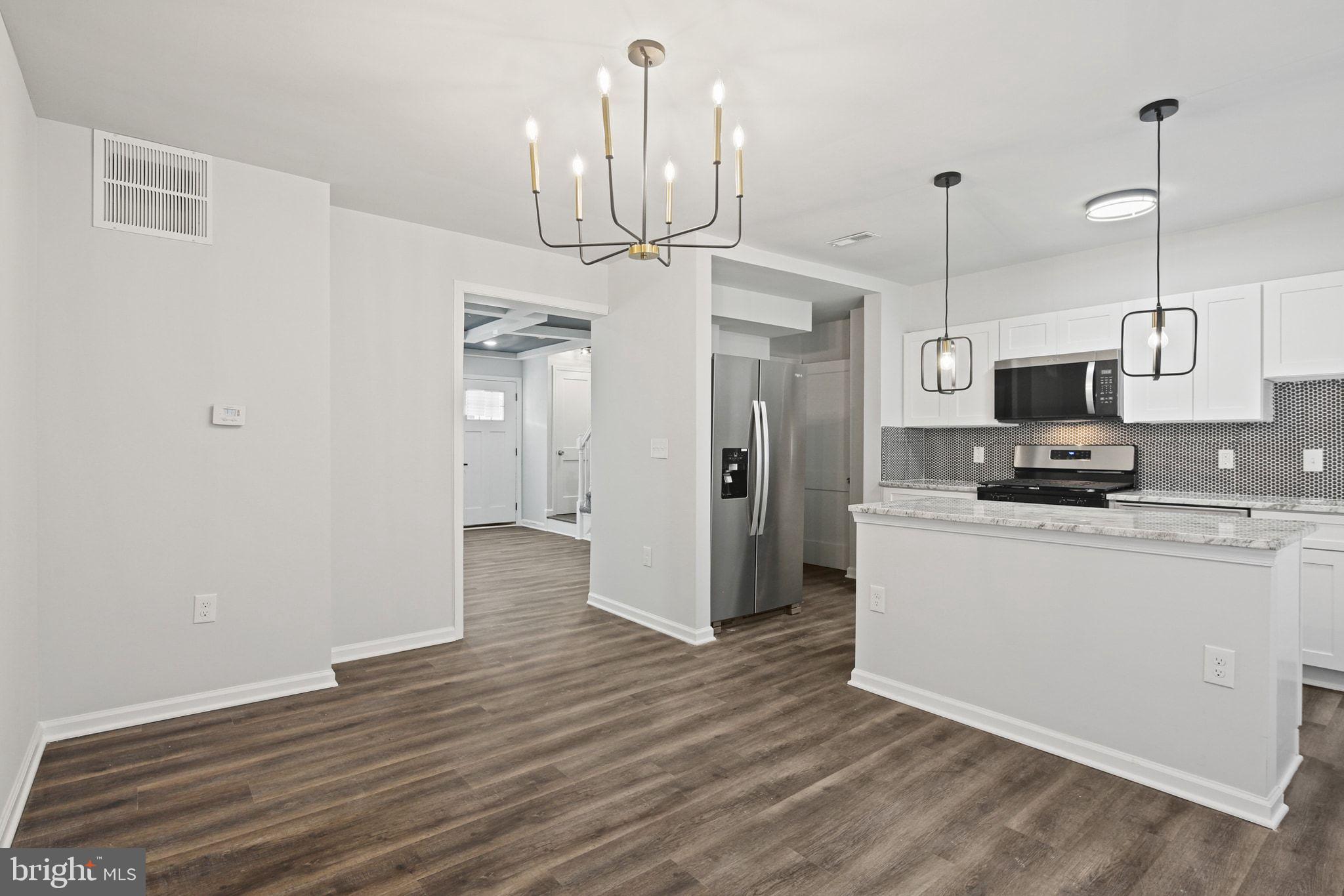 1322 Kitmore Road Baltimore, MD 21239 - Photo 7 of 34 a kitchen with stainless steel appliances granite countertop a refrigerator a stove and a wooden floors