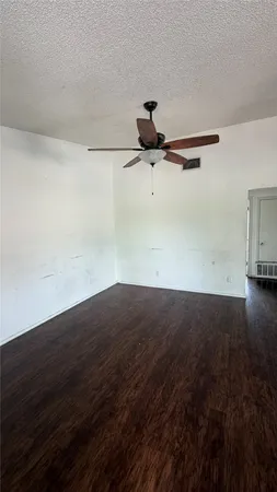 a view of a room with a ceiling fan and wooden floor